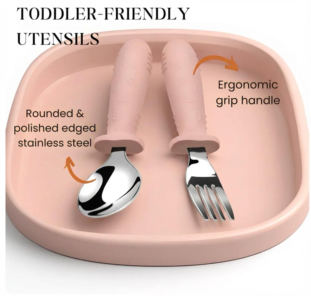 Pink toddler utensil set with spoon and fork on a pink tray, highlighting ergonomic design and material.